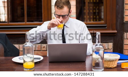 Handsome businessman work at the laptop in restaurant. Close-up.