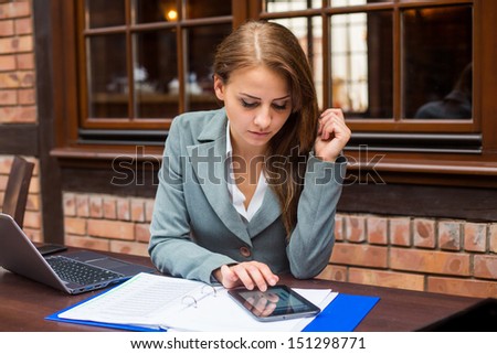 Hard working businesswoman in restaurant with laptop and pad. Close-up.