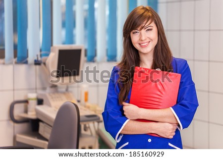 Cute happy female doctor with red notes in hospital