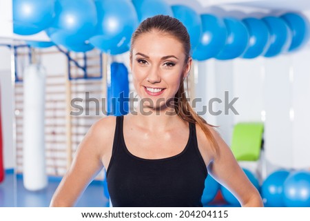 Beautiful happy young woman in gym. Gym shot. Crossfit hall