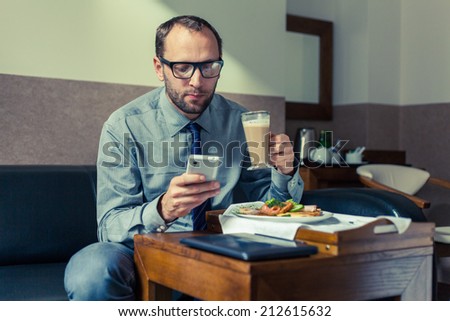 Businessman eating breakfast at home/hotel. Indoor photo