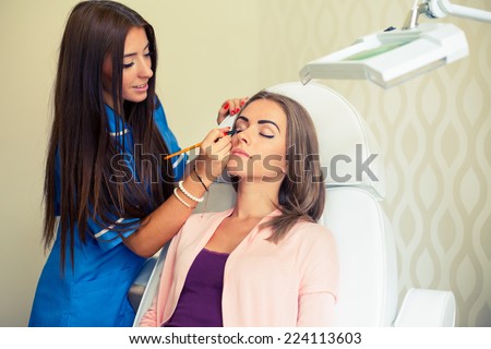 Girl with a beautician at spa salon. Beautician performs cosmetic procedures. Cosmetology, facial, beauty - The concept of facial skin care