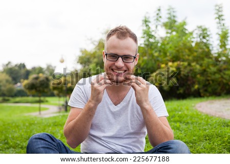 Portrait of bearded young man. Caucasian man smiling happy on sunny summer or spring day outside in park.