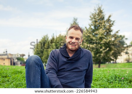 Portrait of bearded young man. Caucasian man smiling happy on sunny summer or spring day outside in park