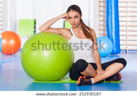 fitness, sport, training and lifestyle concept - woman stretching and doing physical exercises  with big green fitness ball in gym.