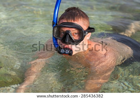 Boy swimming in the sea in mask, and fins.