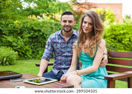 Couple sitting on the bench with drinks and spending great time. Positive emotions