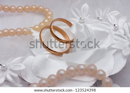 Two wedding rings and pearl on wedding background.