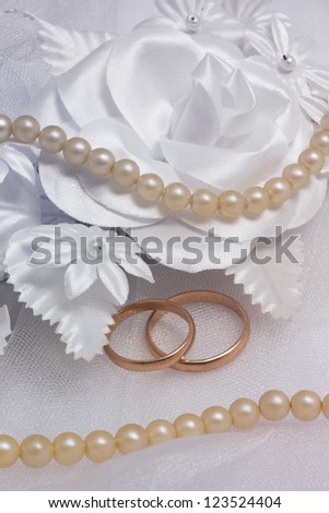 Two wedding rings and pearl on wedding background.