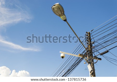 Intertwining of many electrical wires on poles and street lighti