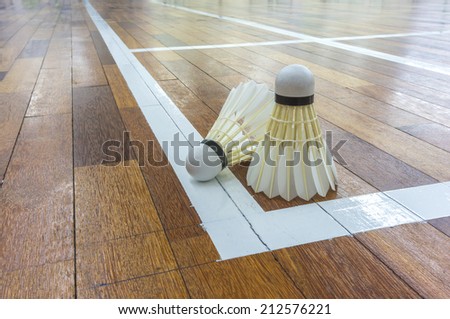 White shuttlecock close up with timber flooring