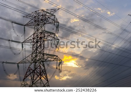 Electricity pylons and cable lines during sunset