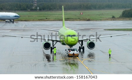 MOSCOW - SEPTEMBER 6: S7 Airlines passenger plane in Domodedovo International, Moscow on September 6, 2013. Airport activity: S7 Airlines green-colored A319 tows from passenger terminals.