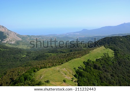 Wide-angle landscape of the broad Alushta valley, illuminated by the late afternoon sun. Wide Alushta valley is bordered by woods, hills and mountains