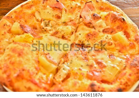 delicious hawaiian rustic style pizza made with fresh pineapples,ham and mozzarella cheese