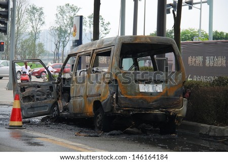 CHENGDU, CHINA - JULY 6: One burned car is abandoned on the road side after the traffic accident on July 6, 2013, Chengdu, Sichuan, China