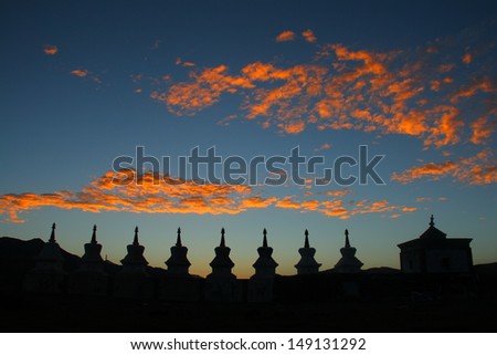Wonderful sunset glow and silhouettes of white stupas on Tibetan Plateau, Qinghai, China