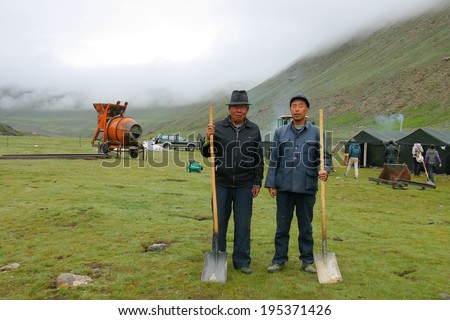 GUOLUO, CHINA - JULY 25: Unidentified road construction workers prepare to go to work on 4000m Tibetan Plateau. They build a road from Sichuan to Xinjiang via Qinghai. July 25, 2013