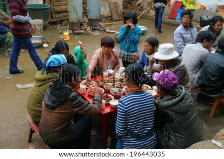 LIJIANG, CHINA - SEPTEMBER 19: Unidentified Mosuo Minority People attend a wedding ceremony and feast, all the dishes are meat, showing respect, September 19, 2013, Linlang, Lijiang, Yunnan, China