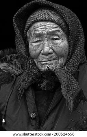 Black and white portrait of a 95 years old woman, born in 1919, with depression, the last generation that bind the feet of woman