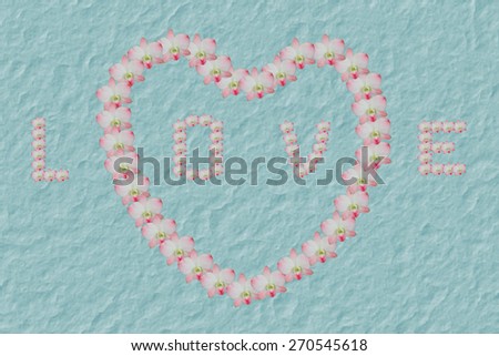 Orchid arranged in a heart on white background made mulberry paper texture