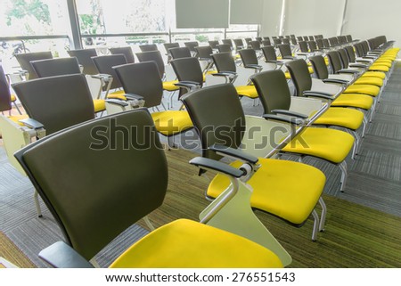 Many yellow chairs arranged neatly in a training room.
