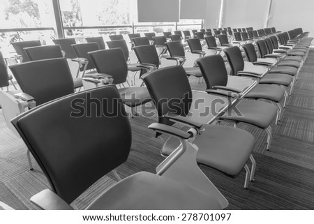 Many chairs arranged neatly in a training room made with black and white color.