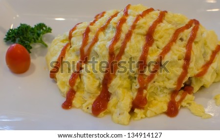 Rice wrapped in egg white dish topped with tomato sauce.