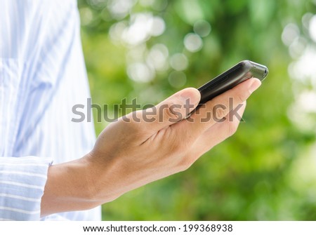 smart phone in hand on green background.