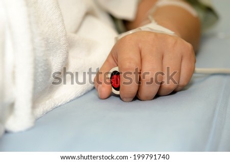 Hand pressing emergency nurse call button