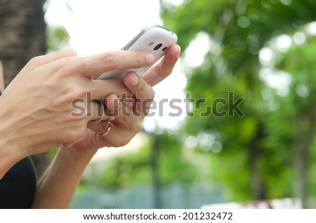 smart phone in hand on green background.