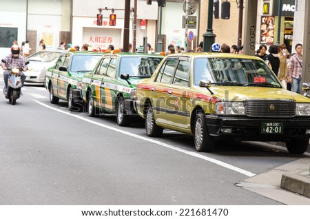 TOKYO, JAPAN - OCT 14, 2013: Yellow and green on the road. Taxi in japan is one of the most expensive in the world.