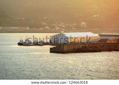 tugboats waiting in port with sunset light