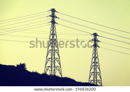 High voltage transmission tower silhouettes with vintage filter effect