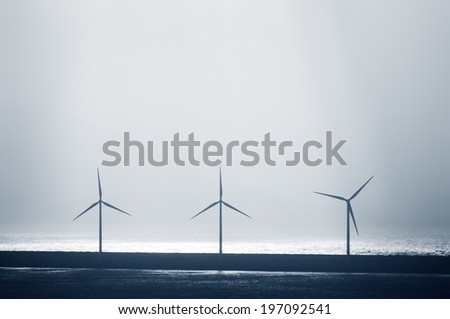 sea wind turbines with sun beams