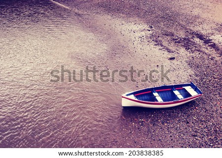 old boat stranded on sand with vintage filter effect