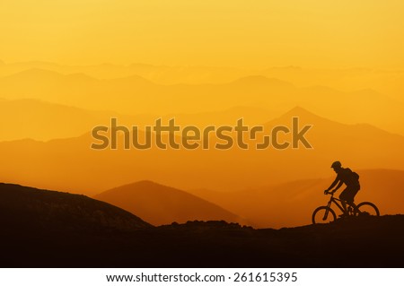 biker riding on a mountain silhouettes background