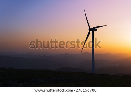 wind turbine silhouette on mountain at the sunset