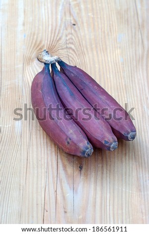 Red bananas on wooden table.