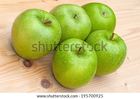Green Granny Smith apples on wooden table