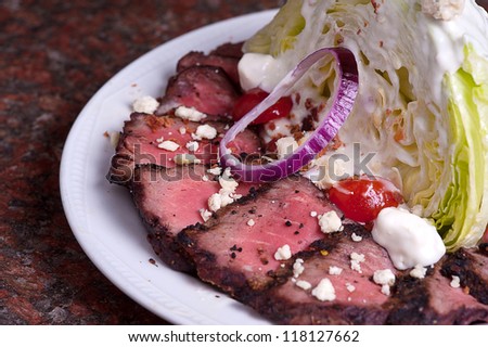 Rare Steak Slices With Lettuce Wedge, Onion, Tomato and Blue Cheese.
