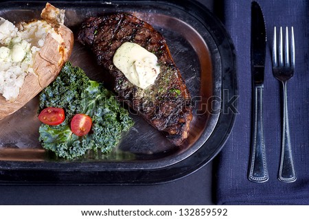 Plated New York Strip Steak With A Baked Potato