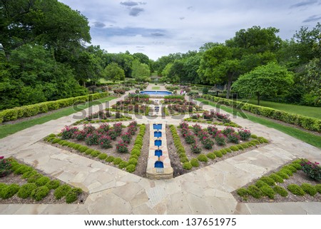 Beautifully landscaped urban rose garden on a cloudy spring day in Texas