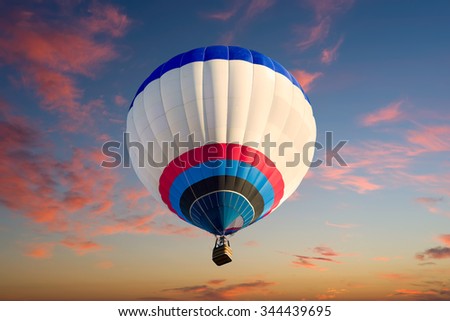 Colorful hot air balloon in flight  illuminated by early morning light