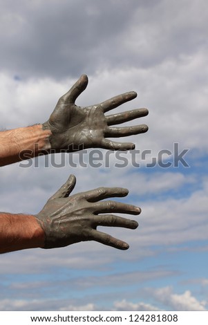 Grey hands on healing clay in the sky