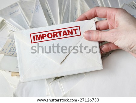 Hand holding a white envelope with the caption 