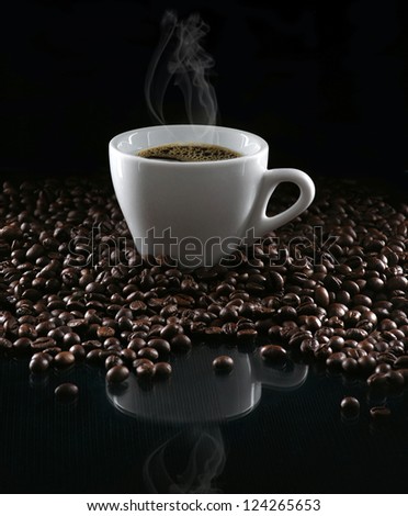 Hot cup of coffee and beans on a dark background