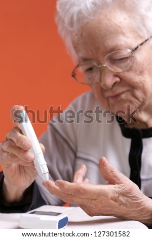 Senior woman checking sugar level Senior woman checking sugar level