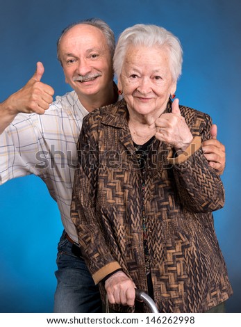 A grown son showing ok with his aging mom on a blue background