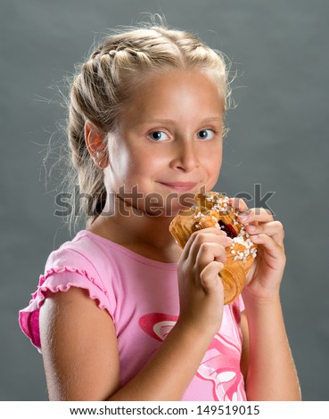 Pretty girl eating cookie on a dark background